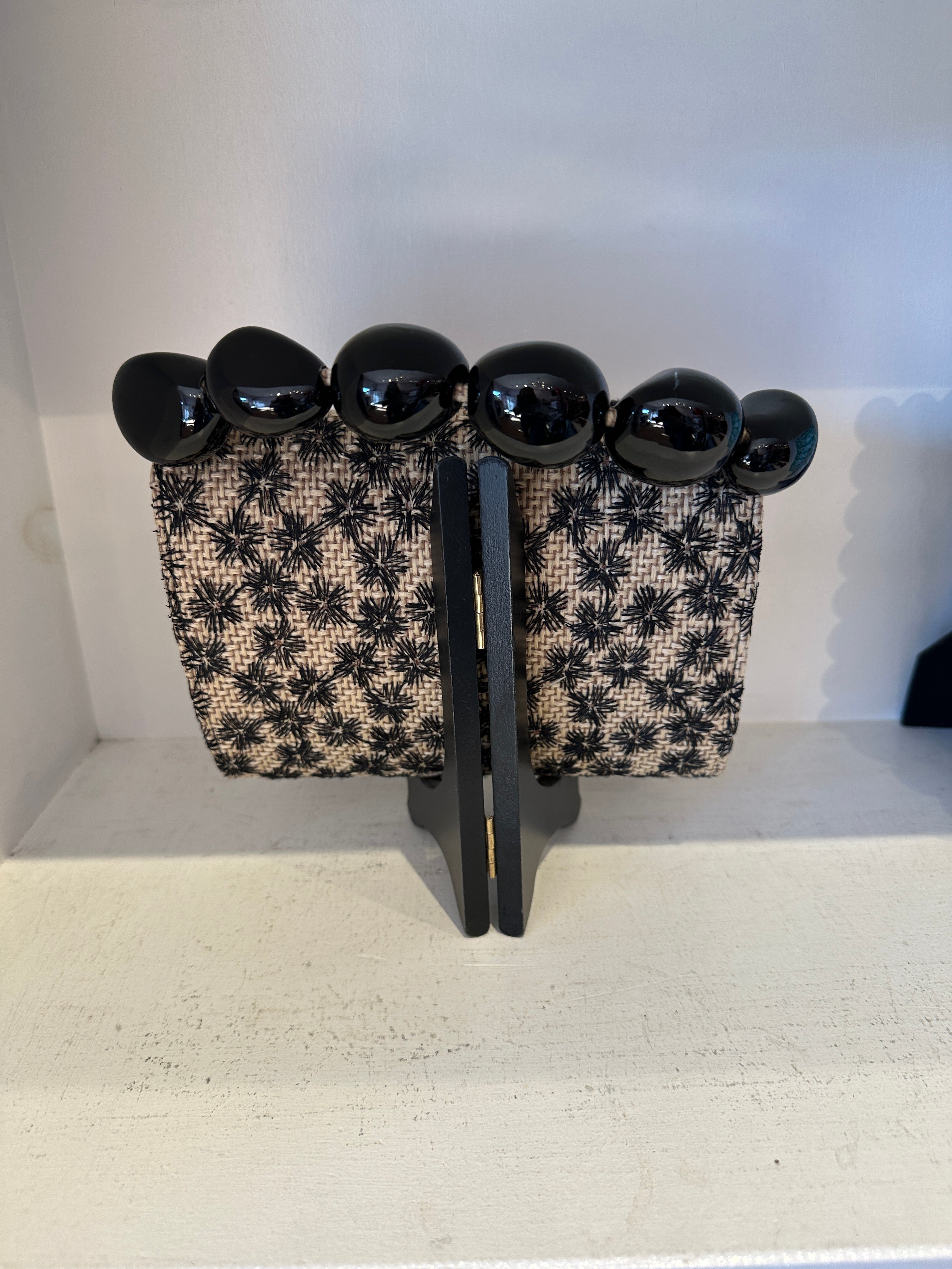 The Nica Rattan Clutch in Black Flowers